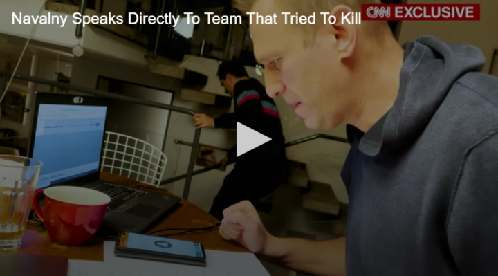 man hunched over table with laptop