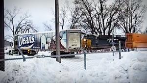 Moment train smashes into truck stuck on snow-covered tracks